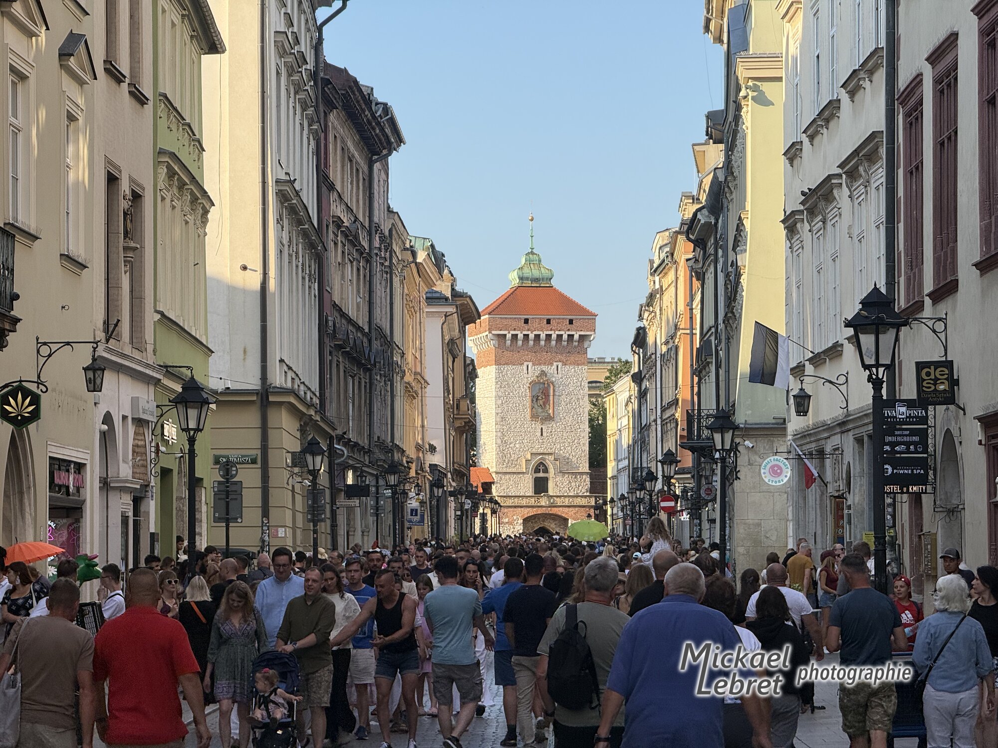 La Rue Floriańska et sa foule du soir, la porte au fond
