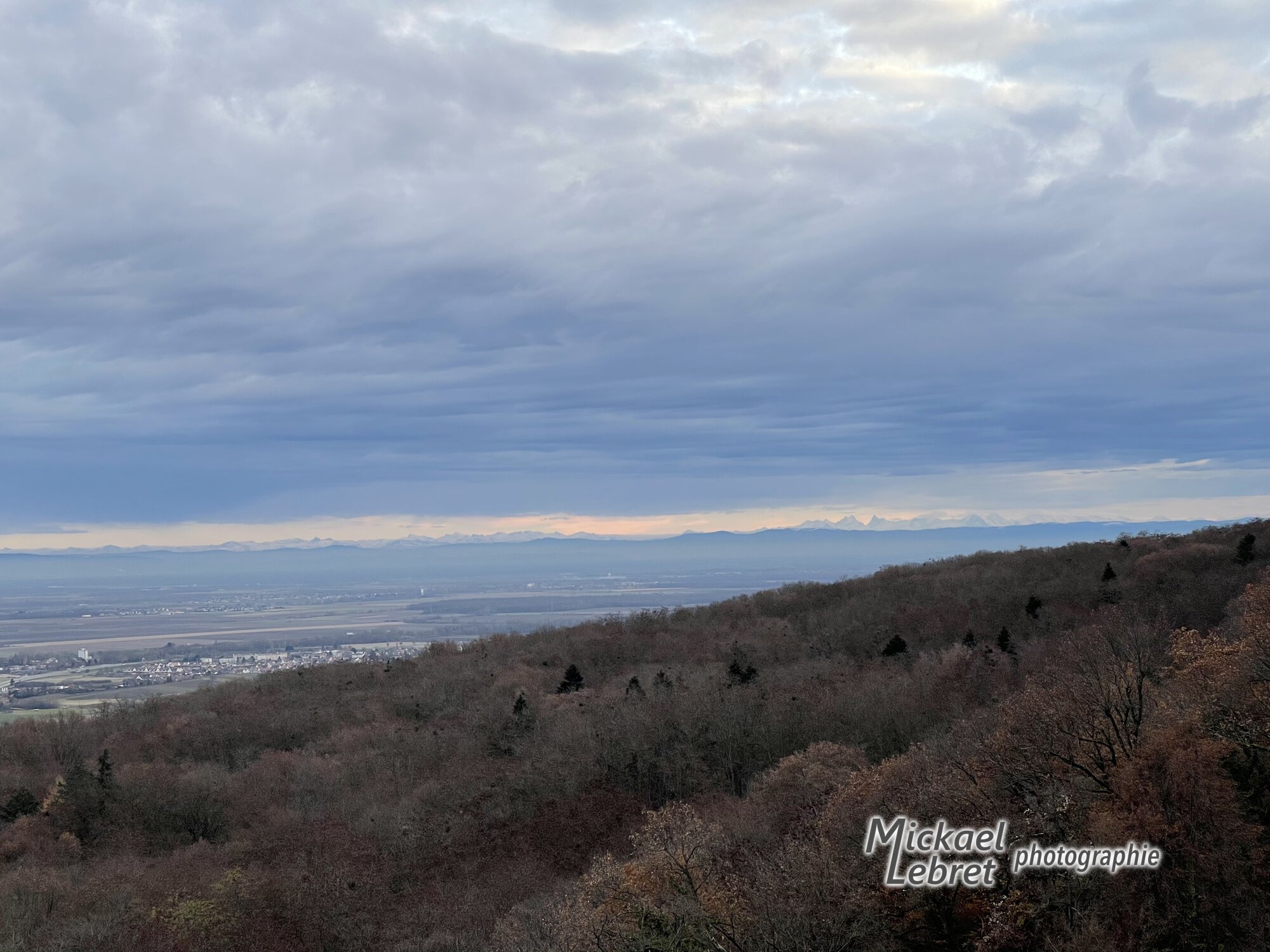 Les Alpes enneigées à l'horizon, au crépuscule, depuis le sentier au-dessus de la chapelle