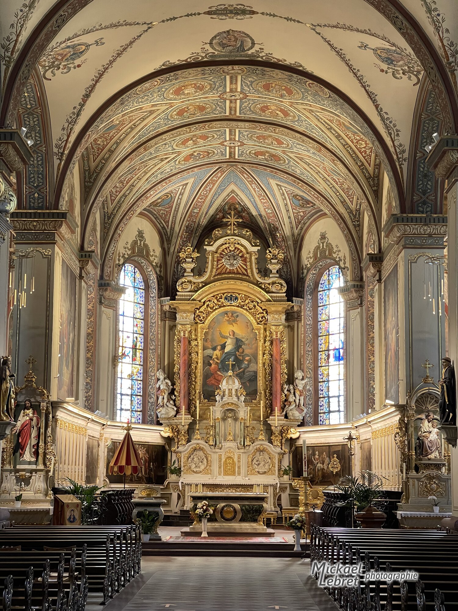 Le chœur de la basilique, son maître-autel doré et ses voûtes peintes