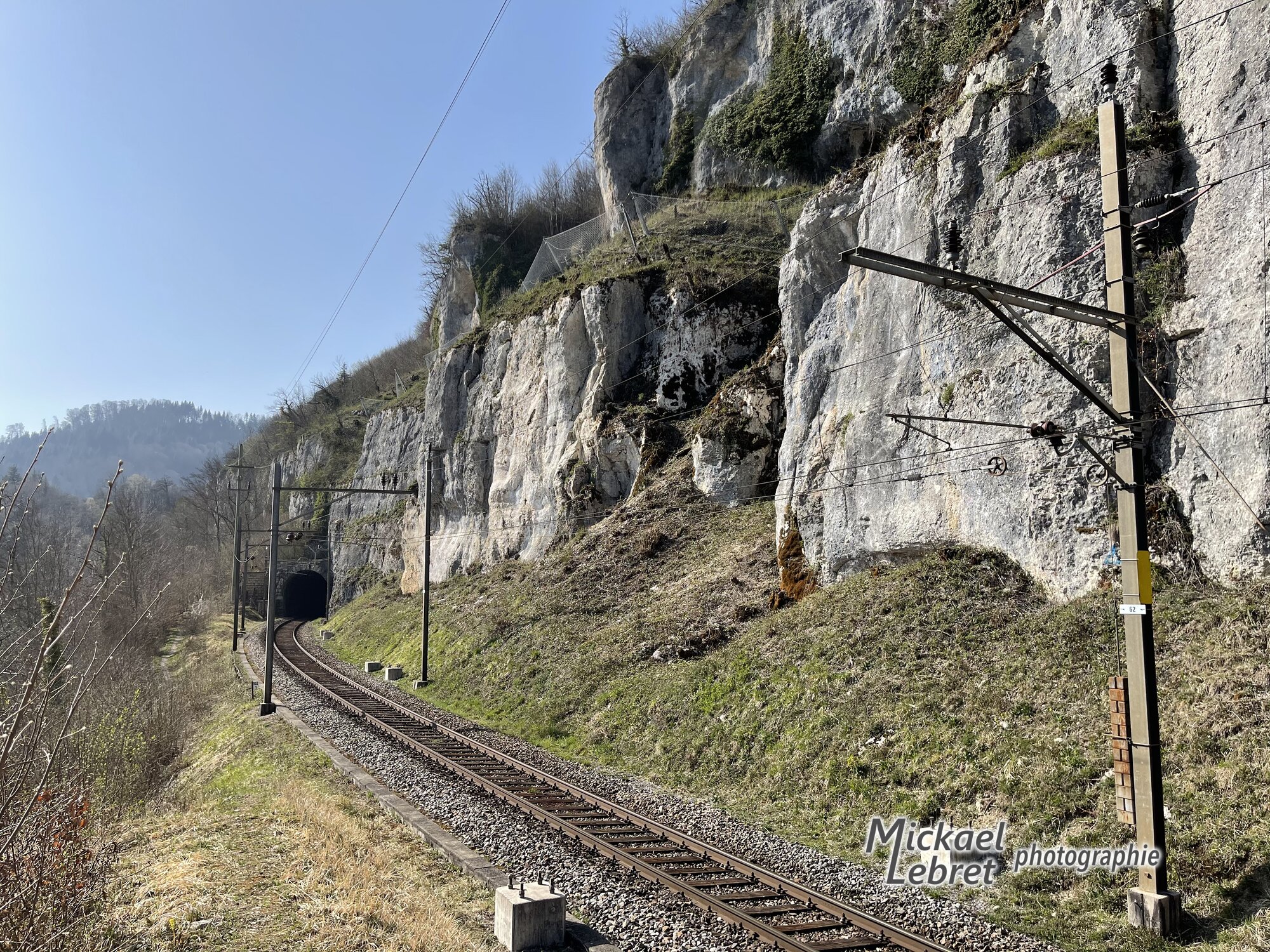 Le sentier longe la ligne Delémont-Delle au pied des falaises calcaires