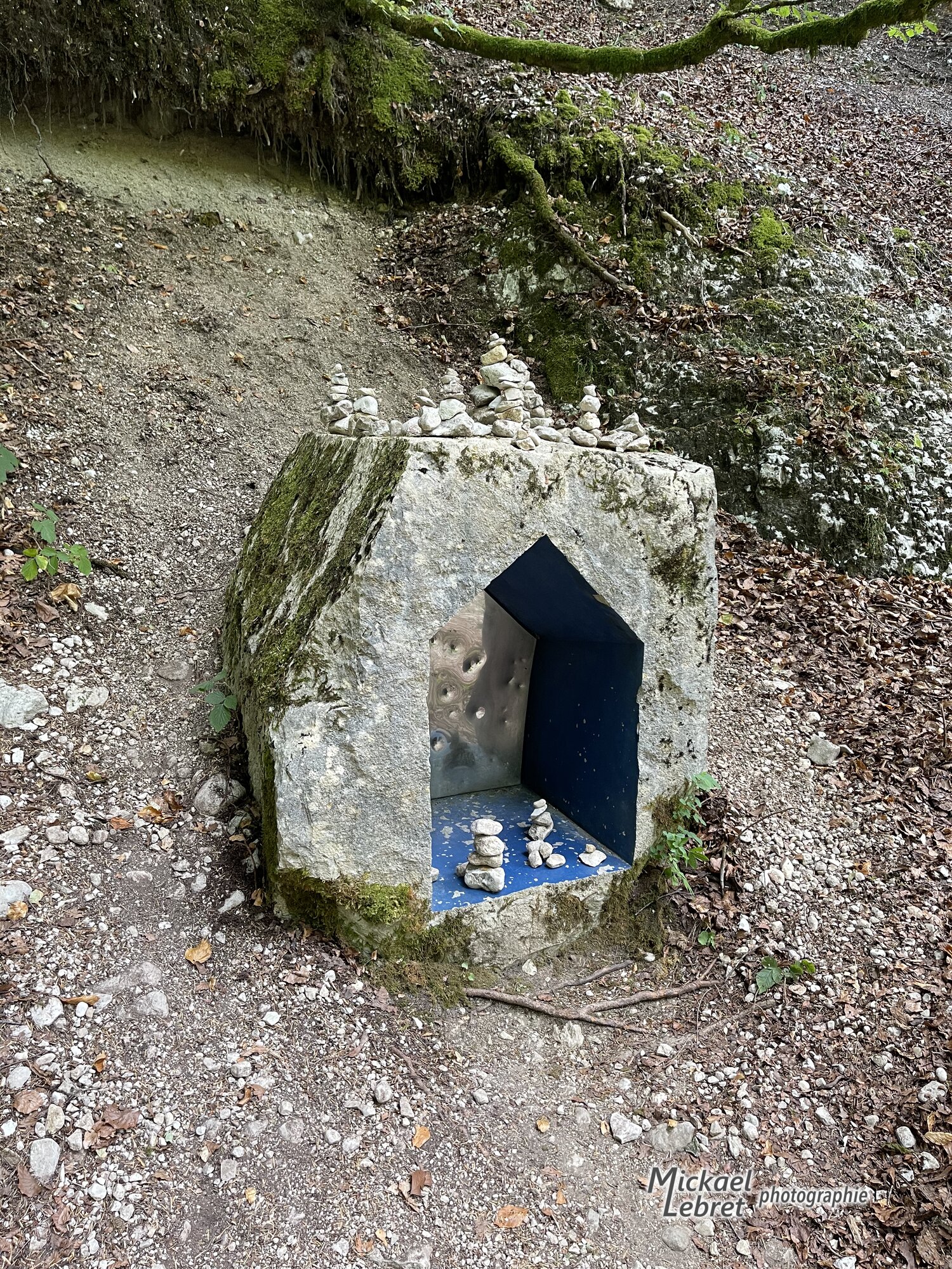Le bloc de calcaire creusé d'une niche bleue, garnie de galets empilés