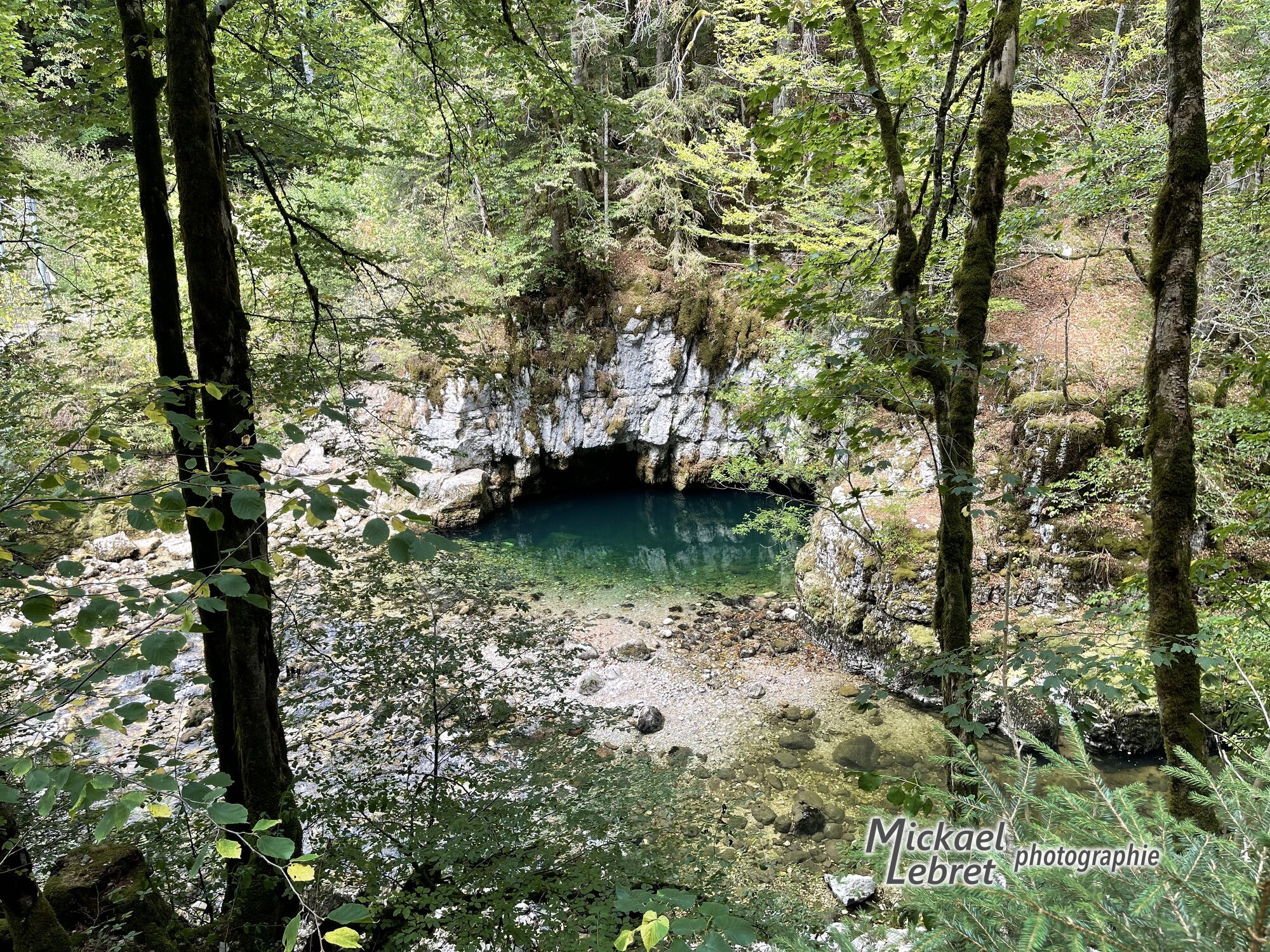 Le Trou Bleu vu du sentier, à travers les arbres