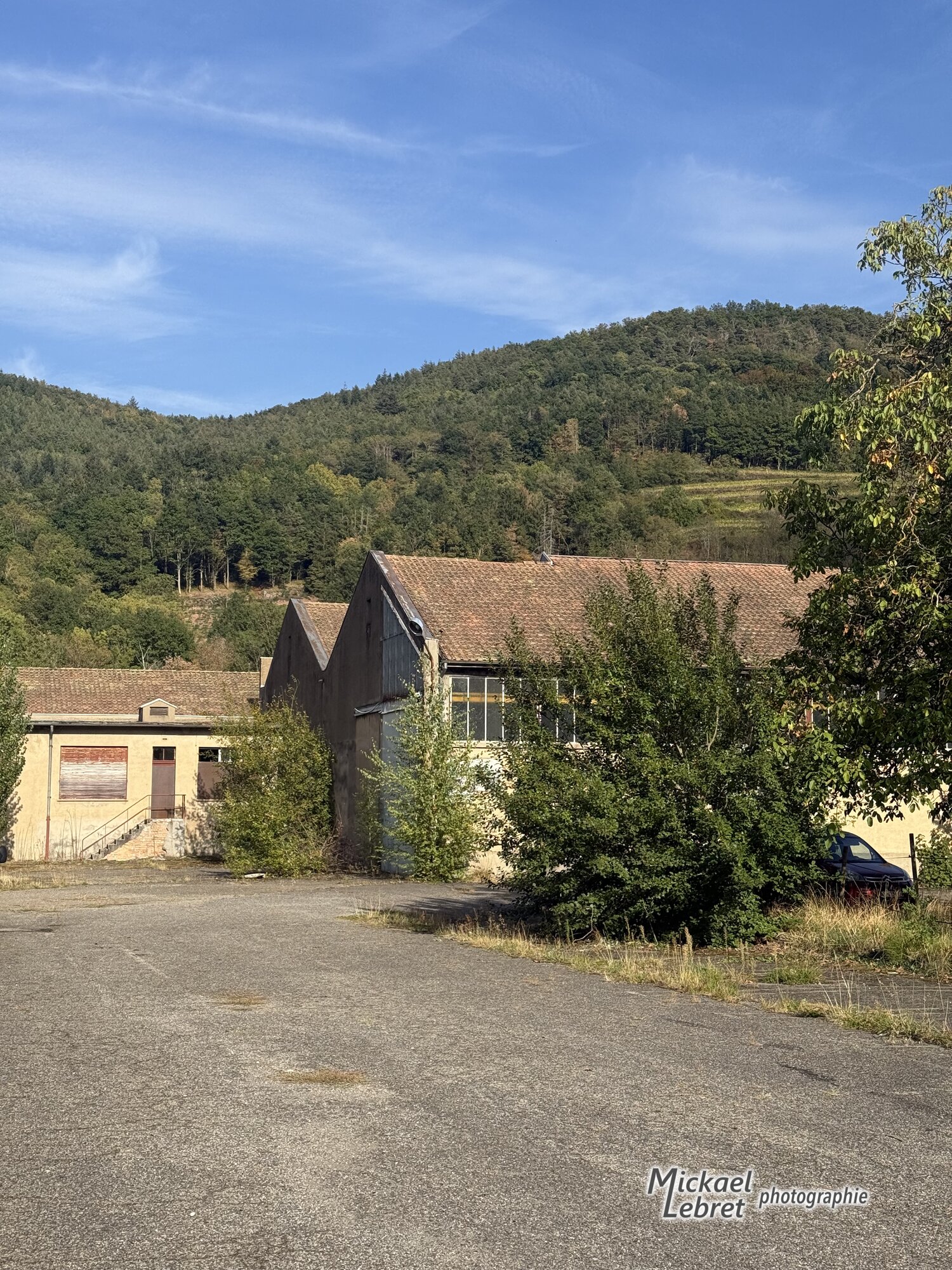 Les bâtiments de l'ancienne manufacture au pied des collines