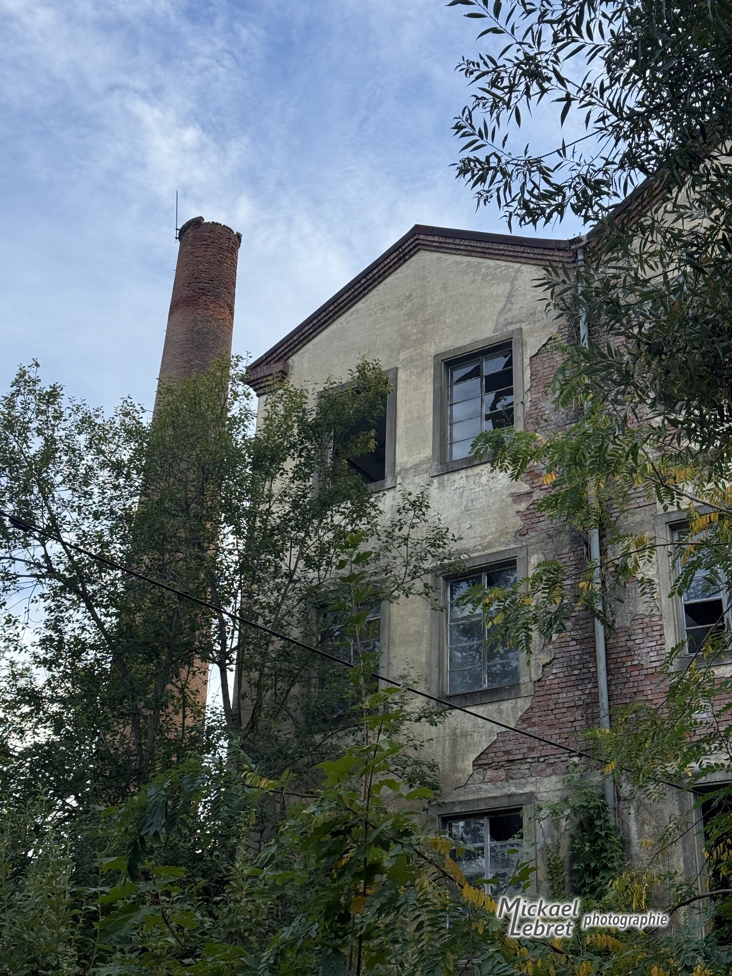 La cheminée et le bâtiment de la filature, gagnés par la végétation