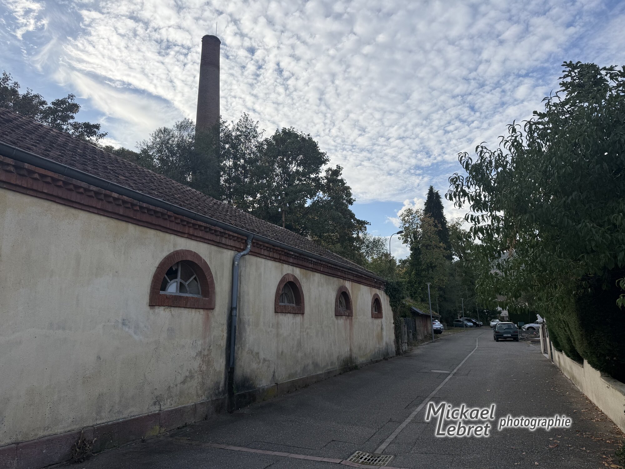 La cheminée de la filature dépasse des toits du quartier