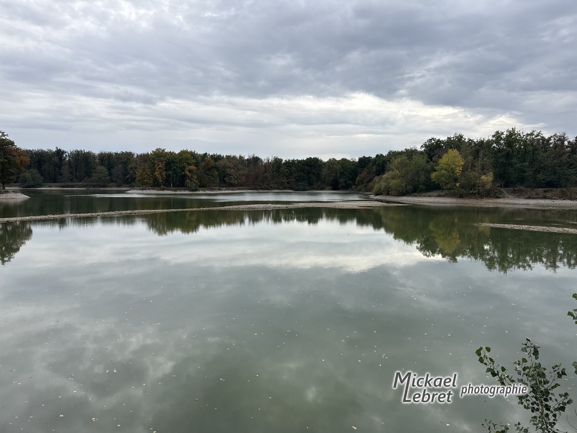 Le plan d'eau et ses bancs de galets, sous les nuages