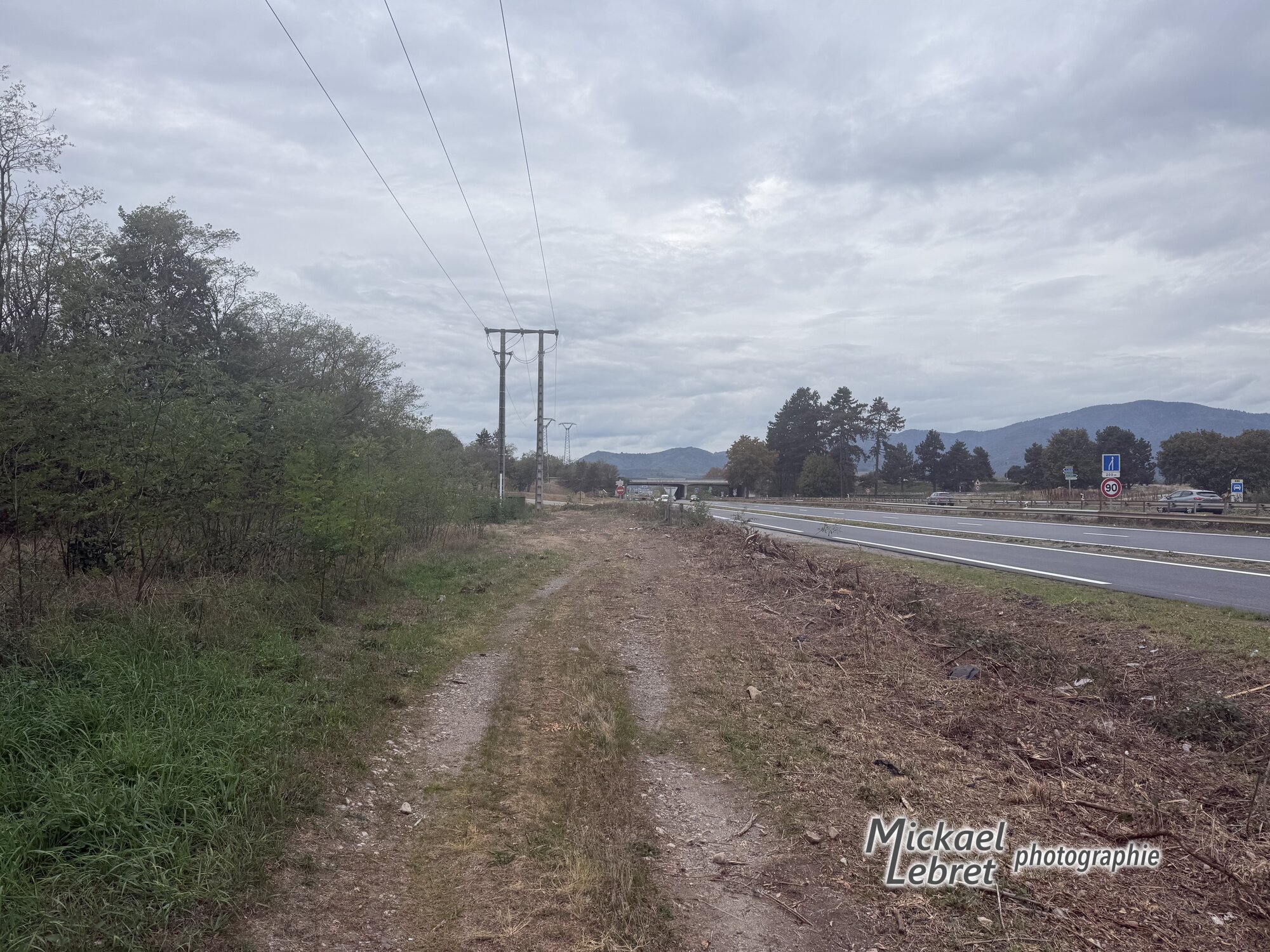 Le chemin qui longe la D1066, sous une ligne électrique